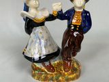 une figurine représentant un homme et une femme se tenant la main