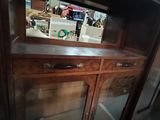a wooden cabinet with a mirror on top of it