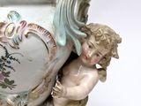a small statue of a boy holding a vase
