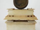 a small clock on top of a stack of books