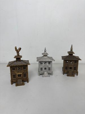 trois bâtiments miniatures sont posés sur une surface blanche
