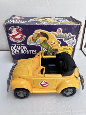 yellow toy car with black roof and door open in front of a box of ghostbus