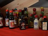 many bottles of alcohol on a table with a wooden box in the background