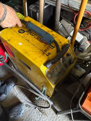 un homme qui travaille sur une machine dans le garage