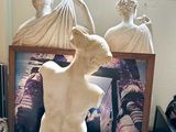 a statue of a woman sitting on a chair in a room