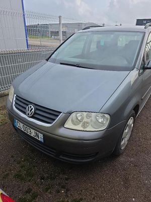 une camionnette grise garée sur un parking près d'une clôture