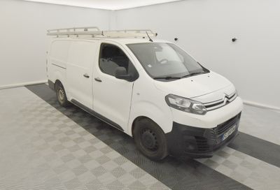 une camionnette Citroën garée dans une pièce blanche au sol à carreaux