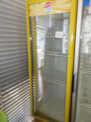 un réfrigérateur avec une porte vitrée dans un magasin