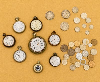 de nombreux types d'horloges et de pièces de monnaie sur la table