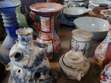 de nombreux vases et bols sur la table de cette pièce