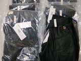 four pairs of pants wrapped in plastic bags on a table
