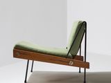 an image of a green chaise lounger in a white room