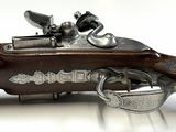 an old gun that is on display on a white surface