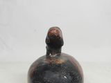 a small black vase with a bird on top of it