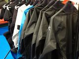de nombreuses vestes suspendues à un portant dans une pièce