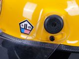 a close up of a yellow helmet with a sticker on it