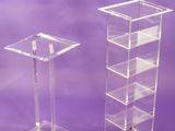 two clear acrylic pedestals on a purple background
