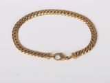 a gold bracelet with a clasp on a white background
