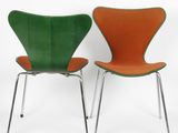 two green and orange chairs sitting next to each other on a white surface