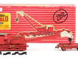 a red toy train with a crane on the tracks