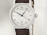 a watch that is sitting on a brown leather strap