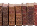 plusieurs vieux livres sont alignés sur une surface blanche