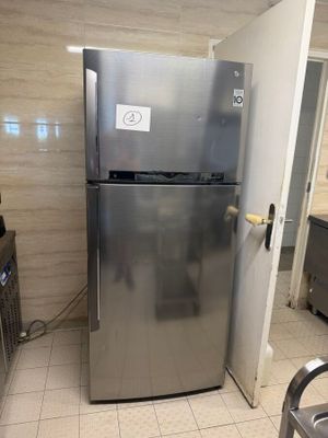a stainless steel refrigerator in a kitchen with tile flooring