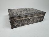 an antique silver box with a floral design on the lid