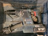 a drill and other tools in a box on the floor