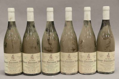 six bouteilles de vin sont alignées sur une table