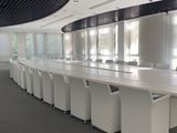 a long table with white chairs in a large room