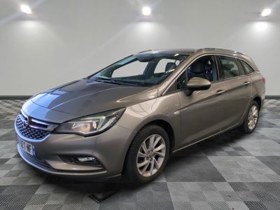 une voiture argentée garée dans un garage au sol en damier