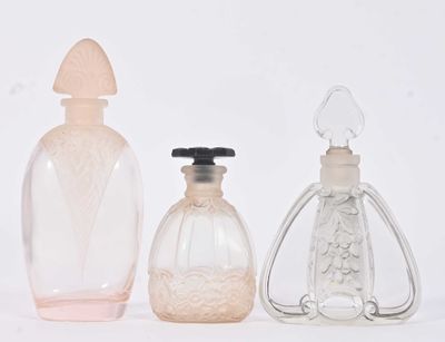trois flacons de parfum posés l'un à côté de l'autre sur une surface blanche