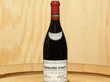 a bottle of wine sitting on top of a barrel
