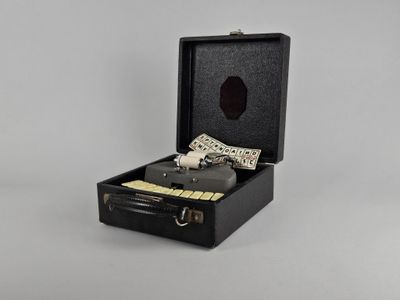 une petite valise noire contenant une clé et un bloc-notes
