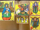 several religious paintings are hanging on a wall in a room