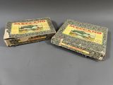 two boxes of meccan cigarettes sitting on top of a table