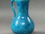 blue vase on a gray surface with a gray background