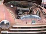 an old rusted car with its hood open