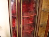 a cabinet with a glass door in the corner of a room