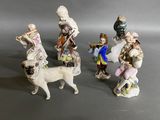 three figurines of people and a dog on a gray surface