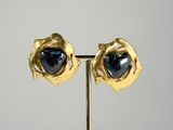 pair of gold and blue stone earrings on a stand