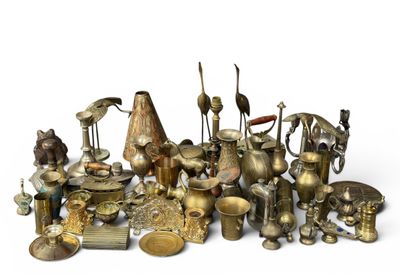 a large collection of brass objects on a white surface
