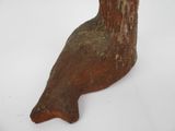 a wooden bird that is sitting on a white surface