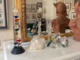 une statue représentant un chat assis sur une table, à côté d'un miroir