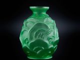 un vase vert posé sur une surface noire