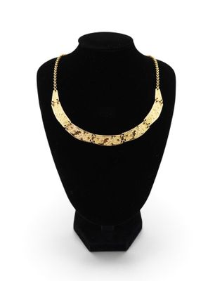 a gold plated necklace on a mannequin display