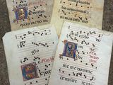 trois vieux manuscrits portant des inscriptions, posés par terre