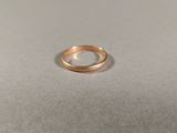 une bague en or posée sur une surface blanche