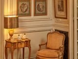 une chaise et une table dans une pièce où il y a des tableaux accrochés au mur